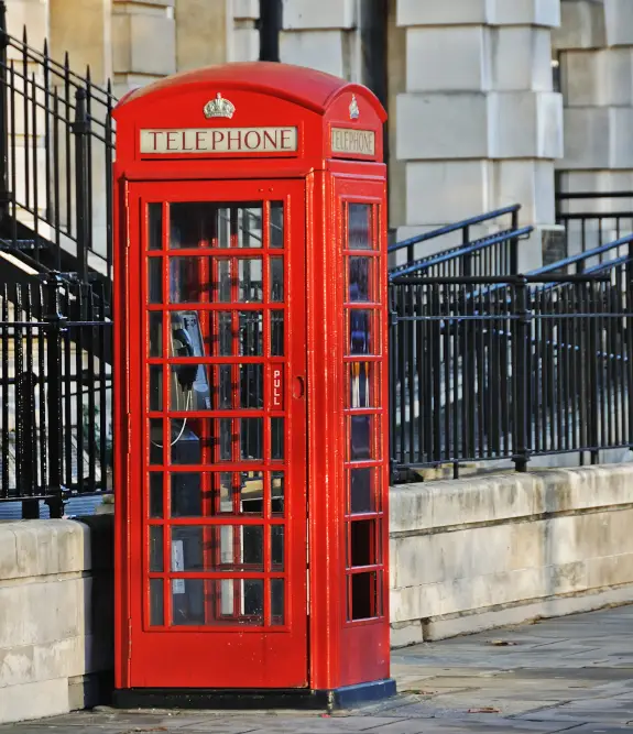 red telephone booth on city sidewalk