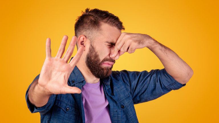 man holding nose because something stinks